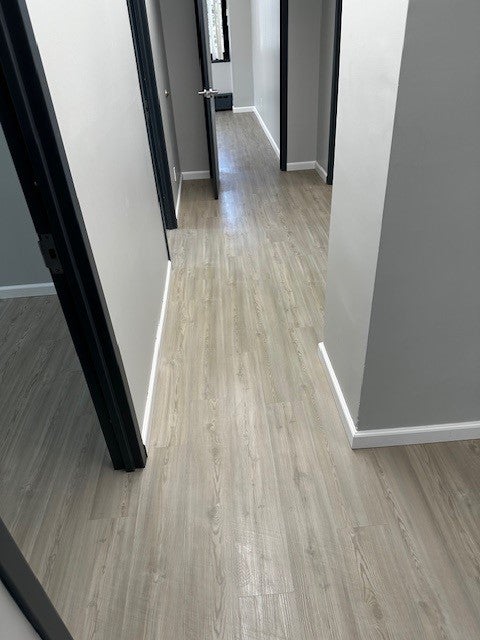 Light wood-look vinyl flooring installed in the hallway by Redi-Cut Carpet in Westchester County